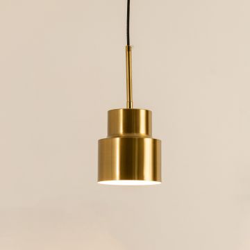 A tiered metal pendant light shining gently against a smooth beige background adding sculptural warm lighting and sophisticated contemporary décor.