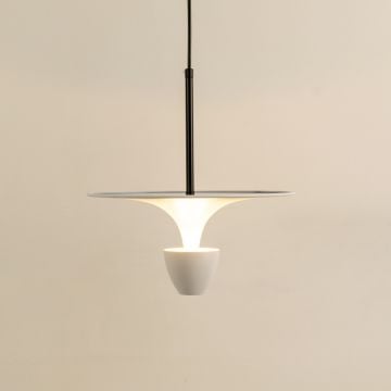 Pendant light with a white flared shade and a dark stem emitting a soft warm glow that creates a calm contemporary ambiance suited for minimal refined interiors.