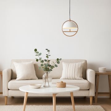 Modern pendant light with rose gold frame and dome shade styled in cozy living room décor above beige sofa.