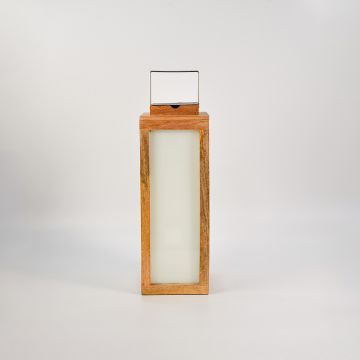 Wood lantern with light on white background displaying soft illumination through frosted glass panels.