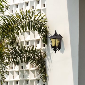 Black outdoor wall light with yellow glass panels mounted on exterior wall for stylish garden and entrance lighting.