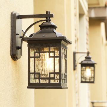 Outdoor wall light mounted on exterior wall illuminating entrance pathway with warm glow.
