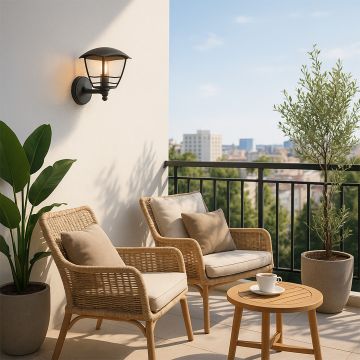 Outdoor wall light mounted on a balcony wall with modern wicker chairs and plants creating a cozy outdoor seating space.