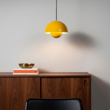 Set of dome pendant lights in orange grey and mustard tones hanging above a wooden table with a cozy sofa creating a warm inviting atmosphere.