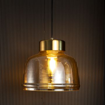 Amber glass pendant lamp illuminated warmly through golden tinted glass shade creating a rich ambient glow against black background.
