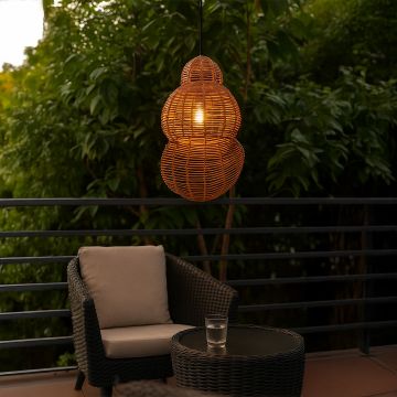 Double gourd rattan pendant light in natural bamboo finish glowing warmly on balcony with outdoor seating.