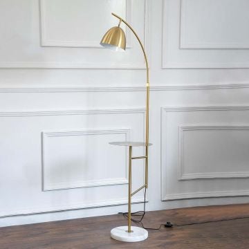 Modern gold floor lamp with round side table and marble base with light turned off on a white background.
