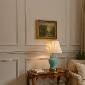 Elegant blue ceramic table lamp with pleated fabric shade styled in a luxury living room.