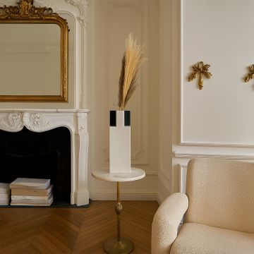 Modern ceramic vase in white and black design styled with pampas grass placed on side table for elegant home decor.