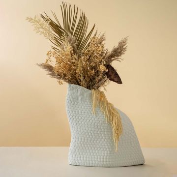 Stylish white textured ceramic vase with dried flowers adding elegance to living room or console table home decor setup.