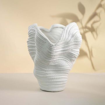 Contemporary tall white ceramic vase with unique handcrafted texture placed on white background highlighting its sculptural artistry.