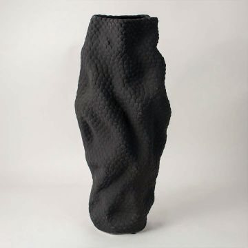 Side view of textured black ceramic vase showing wavy sculptural form and artistic handcrafted detailing on matte surface.