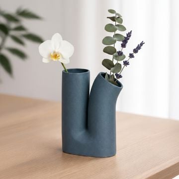 Teal ceramic double neck vase with matte finish styled on living room console table for modern home decor accent.
