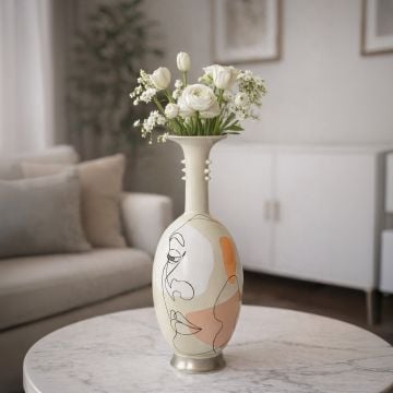 White ceramic artistic face vase with floral arrangement placed on marble table adding elegant modern charm to living room decor.