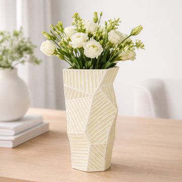 Yellow ceramic geometric vase with fresh flowers styled on wooden table enhancing contemporary home decor setting.