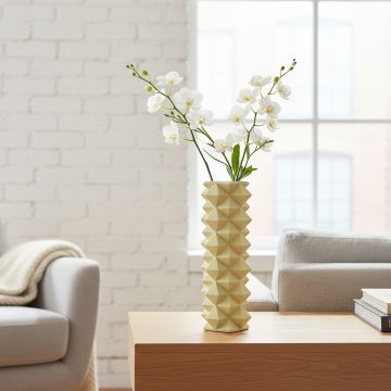 Tall yellow ceramic floor vase with geometric textured pattern placed in living room corner for modern decor styling.