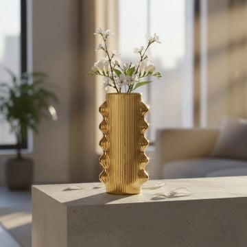 Gold metal textured decorative vase with floral arrangement displayed on console creating luxurious and artistic interior decor accent.