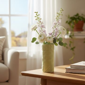 Green ceramic textured vase with floral stems styled on side table enhancing bright and modern home decor setting.