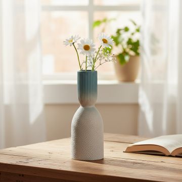 Blue and white ceramic decorative vase with floral stems placed on wooden table adding fresh and modern charm to home decor.