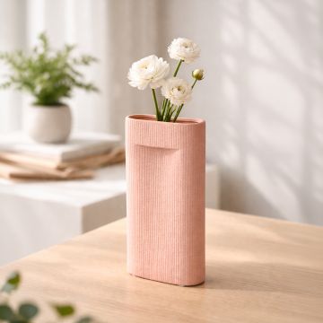 Peach ceramic textured decorative vase with floral stem placed on wooden table adding soft and modern charm to home decor.