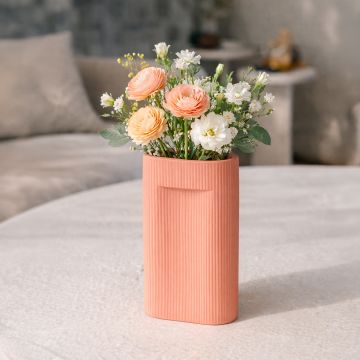 Peach ceramic rectangular vase with fresh flowers styled on coffee table enhancing warm and elegant living room decor.