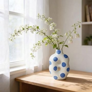 White ceramic decorative vase with blue polka dot design perfect for dried flower display on console table and modern home decor.