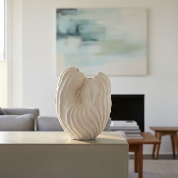 White ceramic sculpted leaf design vase displayed on console table creating elegant and contemporary interior decor accent.