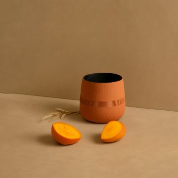 Terracotta textured pot with black interior styled with matching decor pieces creating a warm earthy modern lifestyle setting.