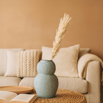 Light blue textured decorative vase arranged in a styled interior adding sculptural artistic decor to living rooms entryways and designed spaces.