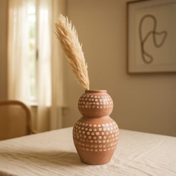Brown terracotta decorative vase with polka dots arranged in a curated modern room adding textured artistic charm to warm interior spaces.