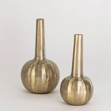 Slim gold vase with sculptural round base shown in styled home setting ideal for modern shelf or table decoration