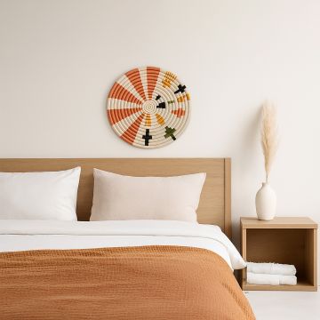 A multicolor woven wall plate mounted above a bed in a calm neutral bedroom setting adding a soft artistic touch that enhances the warm and cozy interior mood.