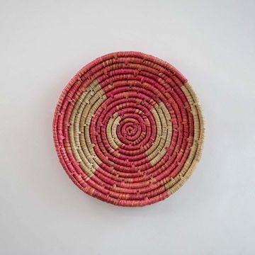 Handcrafted pink wall plate on white background showing detailed woven craftsmanship.
