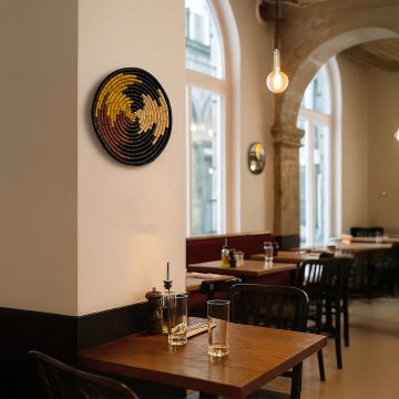 Woven plate styled as wall décor in a cozy living space with pampas grass vase and modern books for aesthetic interior design.