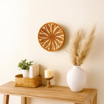 Woven basket wall decor displayed in modern living room with wooden console and pampas grass vase.