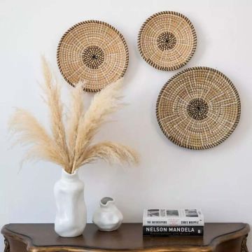 Handwoven wall basket set in natural cane with black detailing styled on wall for modern bohemian living room decor.