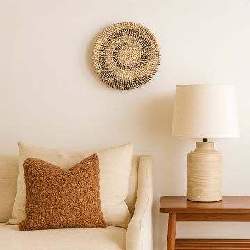 Handwoven wicker basket wall decor in natural beige with black and white circular woven pattern on lifestyle seyup.