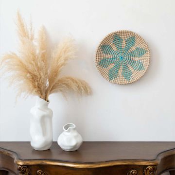 Decorative basket wall art styled above a wooden console with pampas grass in vases modern boho home decor.