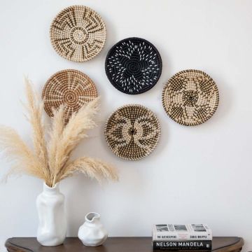 Set of handwoven wall baskets used as boho wall decor in living room with natural rustic style.