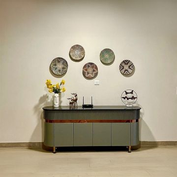 Set of colorful handwoven wall baskets used as boho wall decor above console table in modern living room.