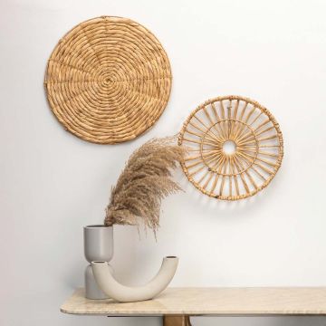 Wicker wall decor adding rustic charm above beige sofa and side table in cozy room setup.
