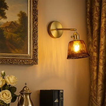 Luxury brass wall sconce with amber glass shade glowing warm light elegant lifestyle setup for living room and bedroom decor.