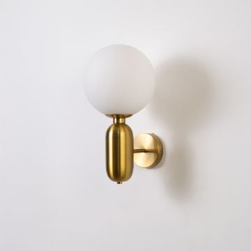 Luxury brass wall sconce with frosted white glass globe shade light off white background for bedroom hallway and living room decor.