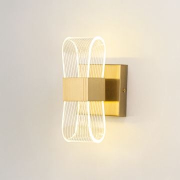 Gold wall light with ribbed clear glass shade illuminated on a clean white background for clear bright visibility.