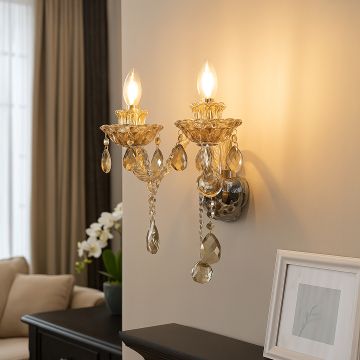 Elegant double arm crystal wall light glowing in living room with modern sofa and floral decor.