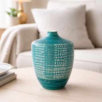 Teal ceramic textured decorative vase placed on coffee table adding vibrant and contemporary charm to living room decor.