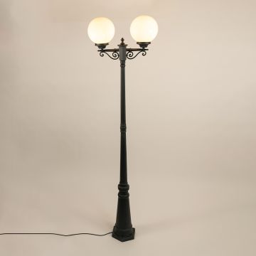 Double-globe outdoor lamp post displayed on a white background with both lights turned on highlighting the elegant black pole and round diffused globes in full view.