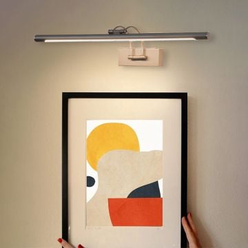 Lifestyle closeup of metal picture light highlighting adjustable bar and premium wall decor lighting.