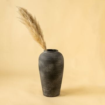 Black textured ceramic vase styled in a modern living room adding a bold minimal accent to consoles shelves and contemporary home interiors.