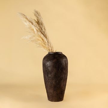 Tall dark textured terracotta vase styled in a warm room setting adding earthy handcrafted depth to modern rustic home decor styling.